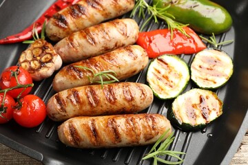 Pan with grilled sausages, vegetables and spices, top view