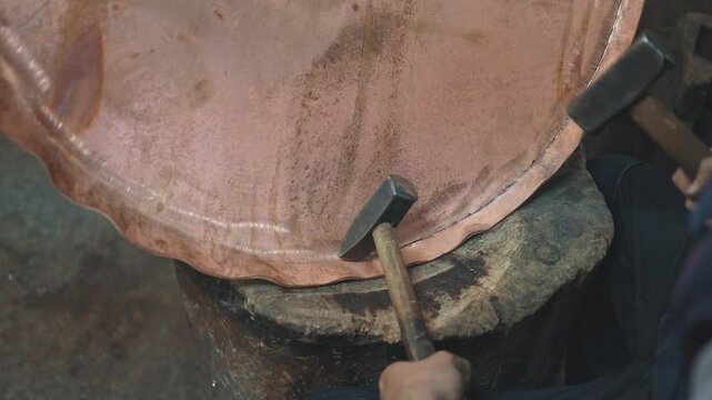 Traditional coppersmith workshop for copper brewing pots manufacturing. This handmade brewery kettles will be used for making traditional alcohol brandy drinks. Small traditional business concept.