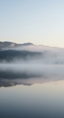Fototapeta premium Misty mountain landscape reflecting in still water