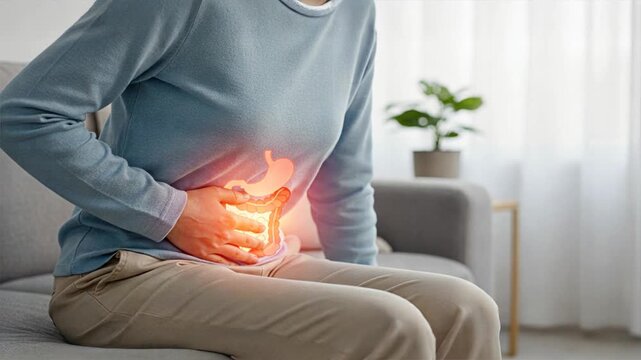 A woman on a couch with glowing digestive overlay symbolizing discomfort, constipation, constipation relief, laxatives