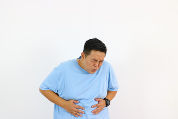 Man experiencing abdominal pain clutching stomach grimacing in discomfort