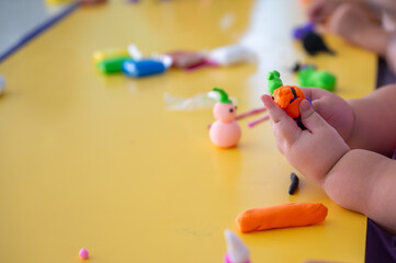 Children crafting colorful foam clay figures during preschool art class, developing creativity, imagination, and fine motor skills through playful hands-on learning in early childhood education.