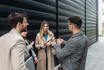 IT experts freelance workers innovative technology developers, working on a new project staff meeting with casual talk in formalwear outside office building before the work. Discussing business people