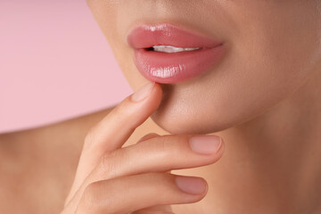 Woman with beautiful lips on pink background, macro view