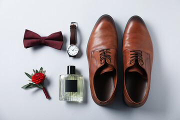 Flat lay composition with stylish boutonniere and shoes on light grey background