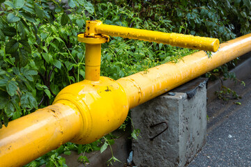 Yellow pipe with a yellow valve on top of it