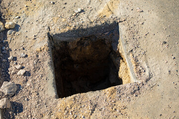 Rectangular hole in the asphalt for installing a fence support