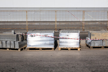 Pile of grey bricks with a red and white rope around them