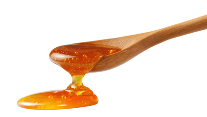Close-up view of a wooden spoon holding golden, viscous liquid dripping onto a surface