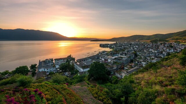 Sunset over ancient Shuanglang town in Dali, China with lake and mountain landscape