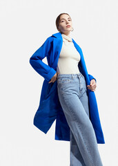 a beautiful woman in a long blue coat on a light background