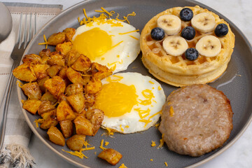 fried eggs along with waffles and home fries