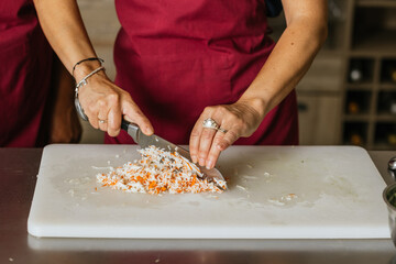 Chef cutting ingredients on chopping board during cooking course