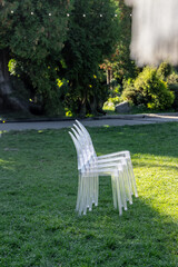 A Collection of Contemporary Transparent Chairs Nestled on Lush Green Grass Surrounded by Nature's Beauty in a Serene Outdoor Environment