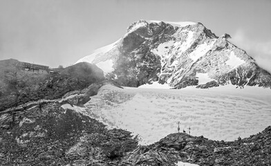 Monte Rosa (Italy) - A mountains view in Valsesia with Monte Rosa mount peak of Alps, alpinistic paths to Rifugio Modena and Capanna Margherita refuge, with snow glacier and alpinists.