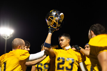 Football player celebrating victory with teammates at night