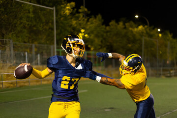 American football players tackling during intense night game