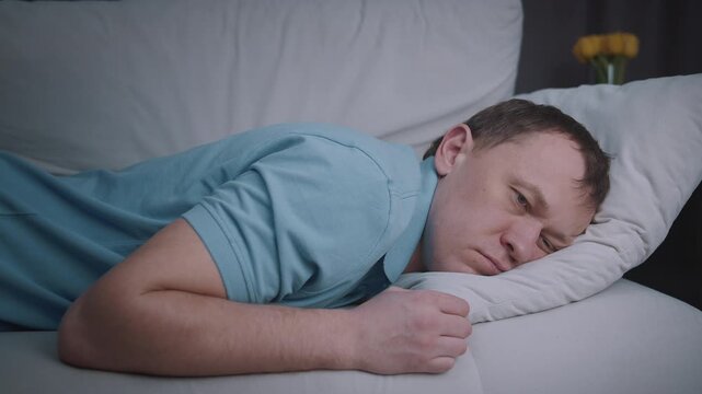 A man enjoying a peaceful sleep on the sofa, assuming various relaxed and comfortable positions