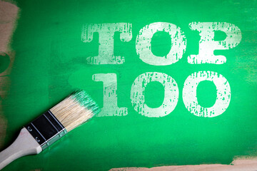 Painted green background with bold white stencil text Top 100 and a paintbrush