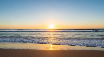 Obraz premium Golden sunrise over ocean waves meeting the sandy beach; serene, peaceful view
