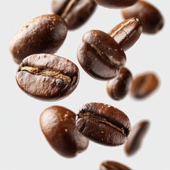 Obraz premium Roasted coffee beans falling in motion on white background, closeup of aromatic caffeine seeds