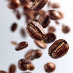 Fototapeta premium Roasted coffee beans falling in motion on white background, closeup of aromatic caffeine seeds