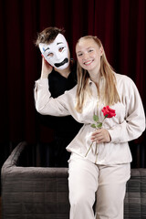 A mime in love and a girl with a rose on a theater stage. Close-up.