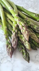 Fresh green asparagus spears on a white marble surface for spring recipes