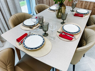 An elegant dining table setting with modern decor, stylish tableware, fashionable cutlery, stunning glassware, and exquisite plates, ideal for hosting and entertaining guests on special occasions