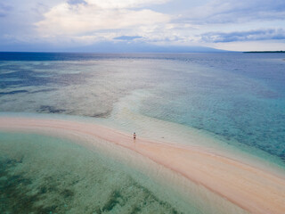 Aerial view of isolated sandbar, turquoise sea and reef, ideal for tropical travel and tourism themes.