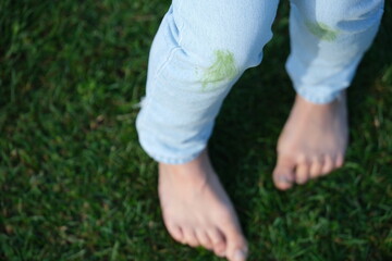 Dirty jeans with grass on their knees on a background of grass. The concept of eco-friendly stain removal on clothes. top view 