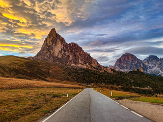 Picturesque and idyllic mountain view of Passo Giau at the sunset. Scenic mountain road and rocky peaks. Dolomites, Italy