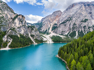 Lago di Braies or Lake Braies crystal blue lake with wooden rowing boats in Italian Dolomites. Mountain forest lake in Italian apls Dolomites South Tyrol. Mountain summit ridge. Glacier lake. 