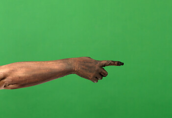 A creepy zombie hand points to the side