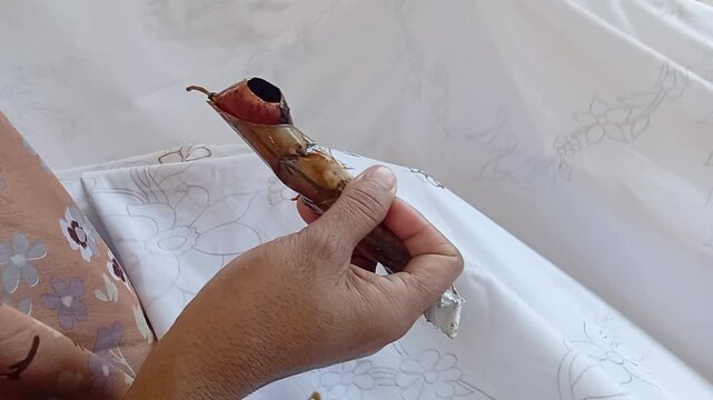 Hand holding a canting to batik cloth