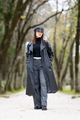 Woman walking along tree lined park alley