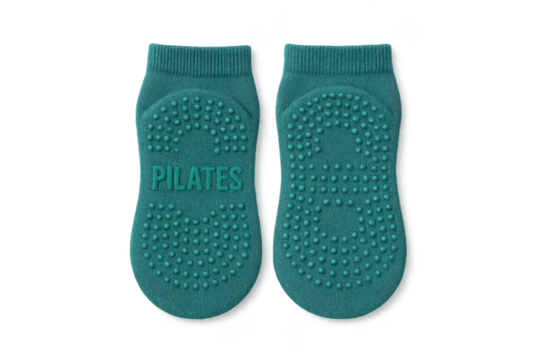 Pair of teal Pilates anti-slip grip socks isolated on transparent background