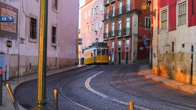 A classic fampus  yellow tram passes by vibrant red historic buildings in Lisbon  early sunrise morning