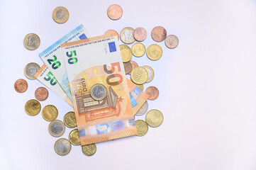 Euro banknotes with coins scattered on clean white background. Concept photo for finance, savings, banking, economy, currency exchange, investment, payments, European money background with copy space