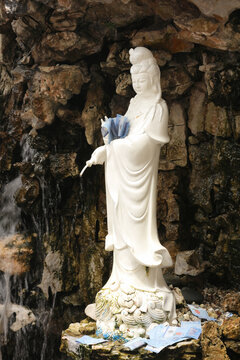 Goddess of Mercy Guanyin Pouring Nectar, Adorned with Malaysian Banknotes and Coins as Offerings, Sculpture at Buddhist Temple in Kuala Lumpur.