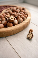 Composition of assorted nuts and seeds on a wooden surface with soft natural light. Seasonal autumn concept, healthy lifestyle, and organic food background.