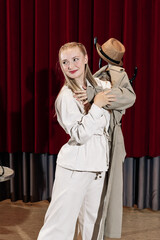 An actor performs on the theatre stage with his coat on a hanger