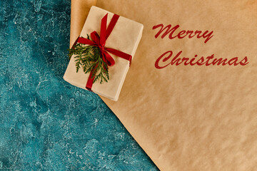 A gift with a ribbon rests on a colorful winter background, spreading holiday cheer.