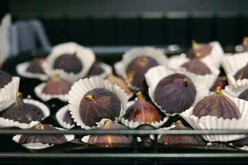 Close-up of fresh figs displayed on supermarket shelf, ready for sale.