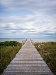 Obraz premium Wooden boardwalk leads to the ocean horizon