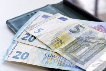 Euro banknotes on the table. Twenty and five euro notes on phone. Business and finance concept.