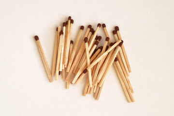 Wooden Matches in Loose Pile. Closeup of wooden matches with brown tips loosely arranged on neutral background.