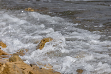 The rough Adriatic Sea in Croatia, waves lapping the stones on the beach Rab Croatia