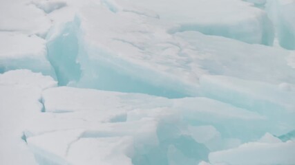 Fractured polar sea ice with blue-tinted slabs and ridges, showcasing frozen textures, jagged cracks, and minimalist patterns across a cold ocean surface in winter light. - Powered by Adobe