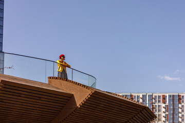 A young woman in bright autumn clothes walks through the city streets in autumn.